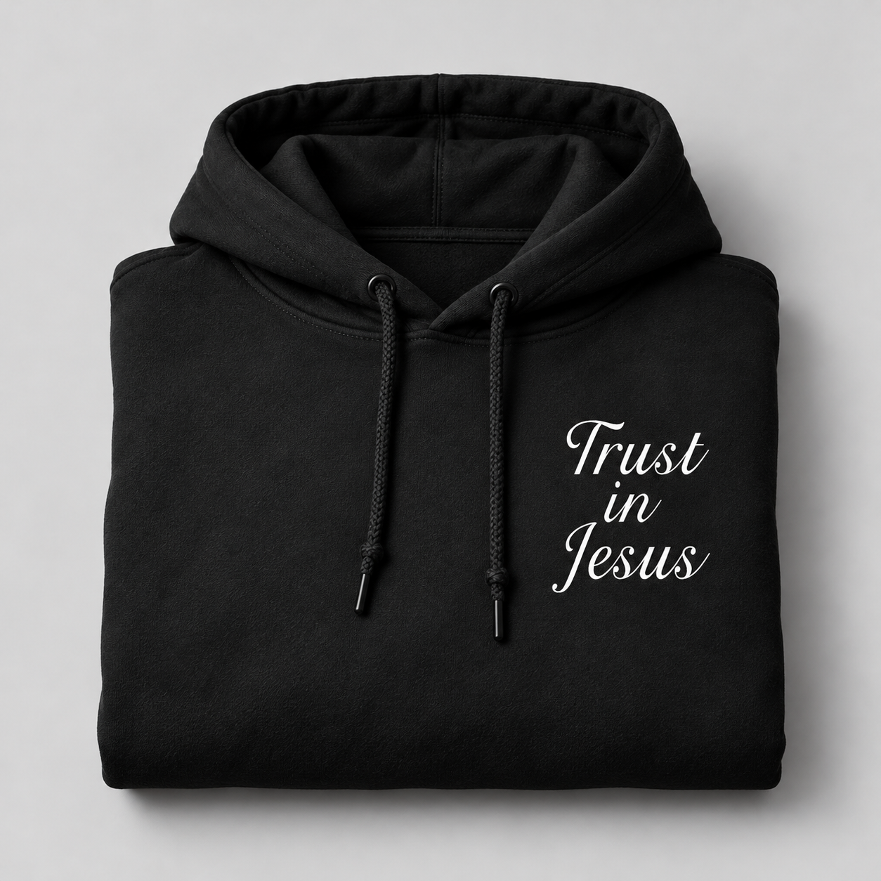 Black Trust in Jesus Hoodie, folded, white script chest design